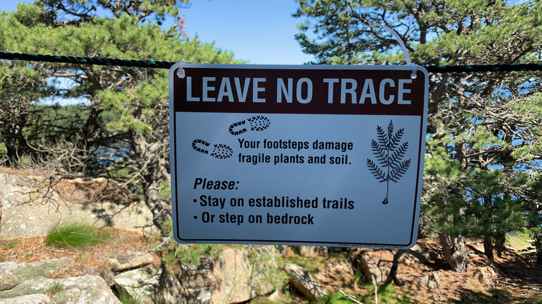 sign reading "Leave no trace. your footsteps damage fragile plants and soil"