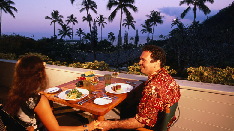 Couple enjoying a romantic dinner in Maui overlooking the ocean.