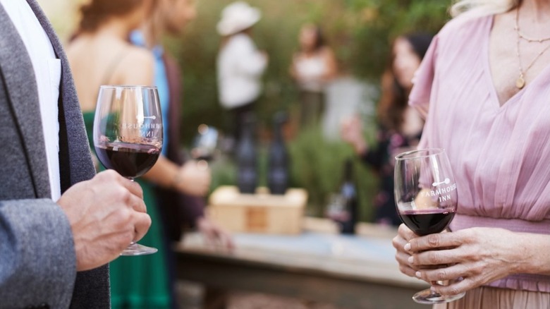 Couple holding red wine glasses