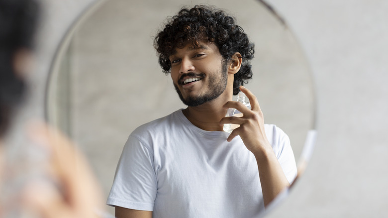 man applying cologne