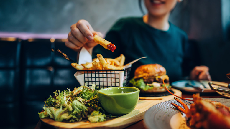 Woman eating a burger and fries