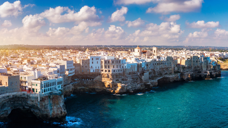 A whitewashed city on cliff near ocean in Puglia