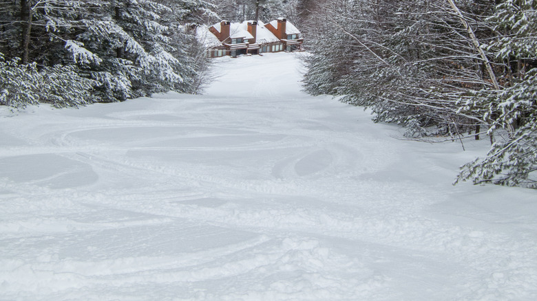 Snowy ski run leading to lodge