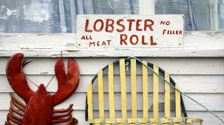 A sign advertising lobster rolls outside of a Maine lobster shack