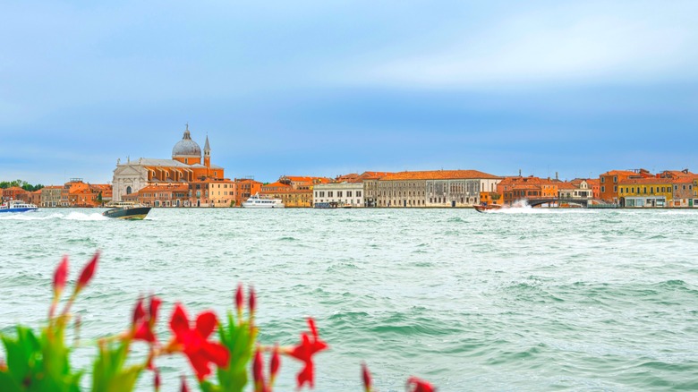 Boat cruising on the Venice Lagoon in front of historic buildings