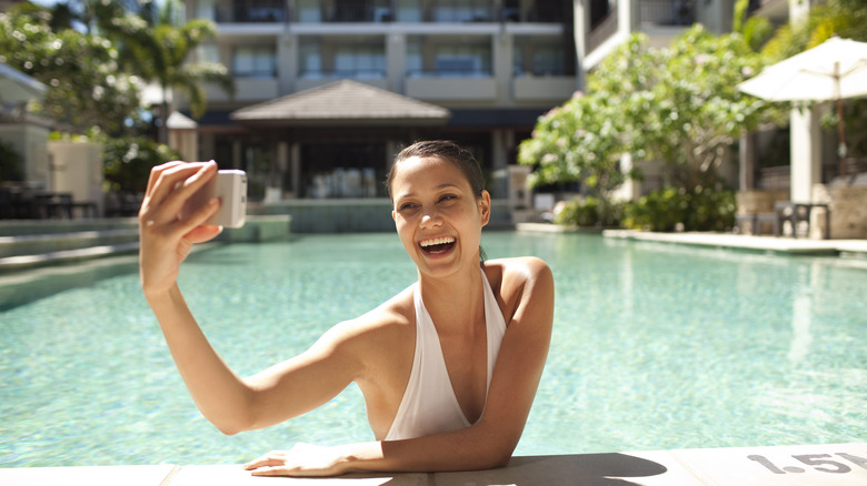 Woman taking selfie in pool