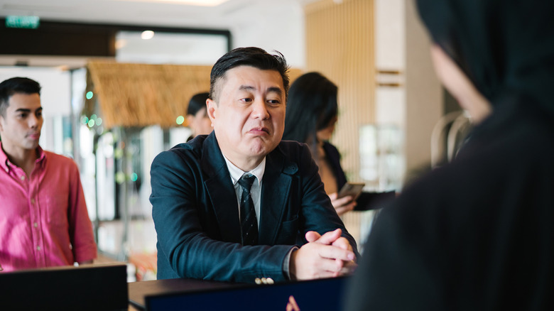 Man talking to hotel receptionist