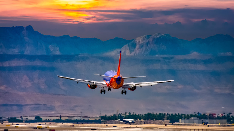 Airplane over mountains during sunset