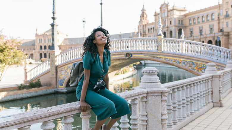 woman smiling near bridge and castle