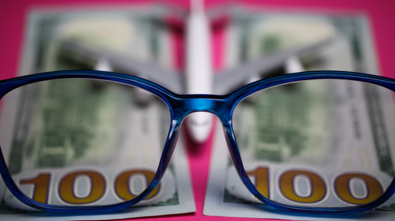 Eyeglasses over plane and money