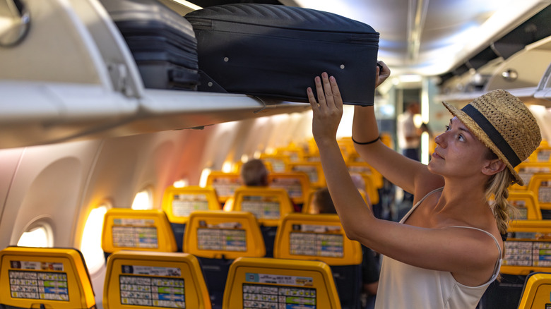 Passenger storing carry-on suitcase