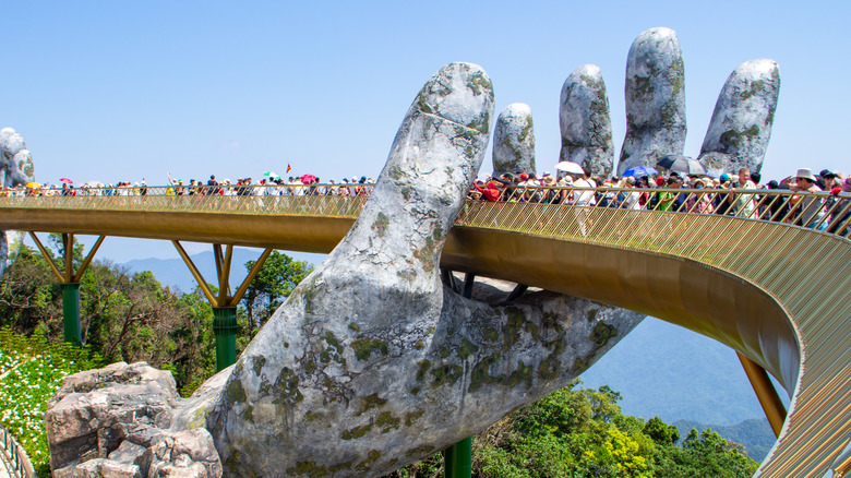 atone hand holding golden bridge