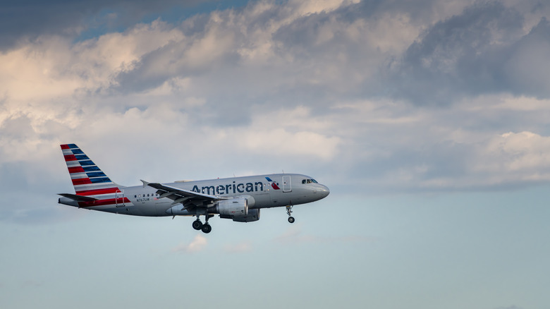 American Airlines plane flying with a cloudy sky