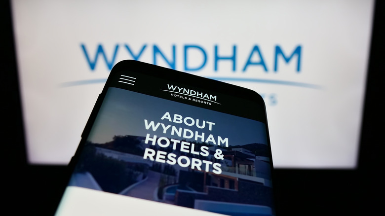 A phone is held up to a Wyndham sign