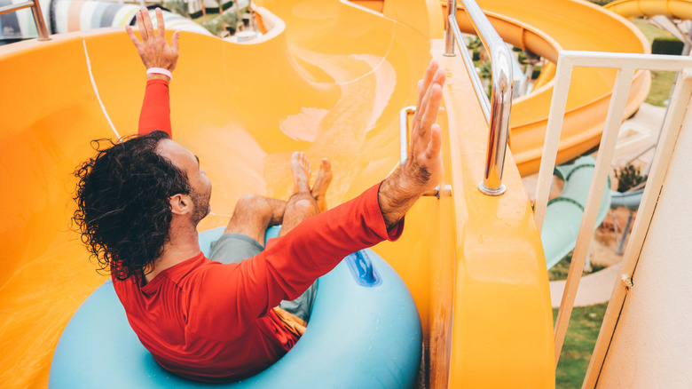 Man riding down a waterslide in a tube