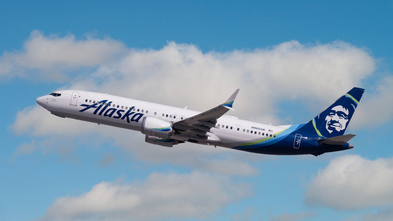 Alaska Airlines plane shown taking off with sky backdrop