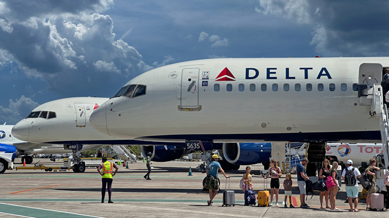 passengers boarding a Delta Air Lines plane from tarmac