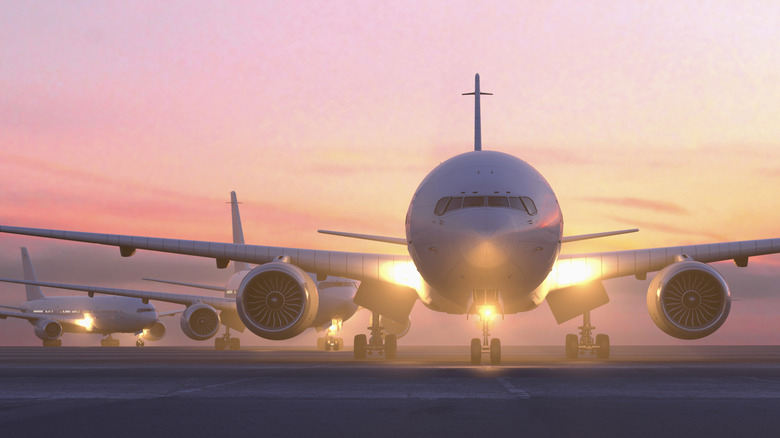 shot of front of airplane at dusk with pink sky