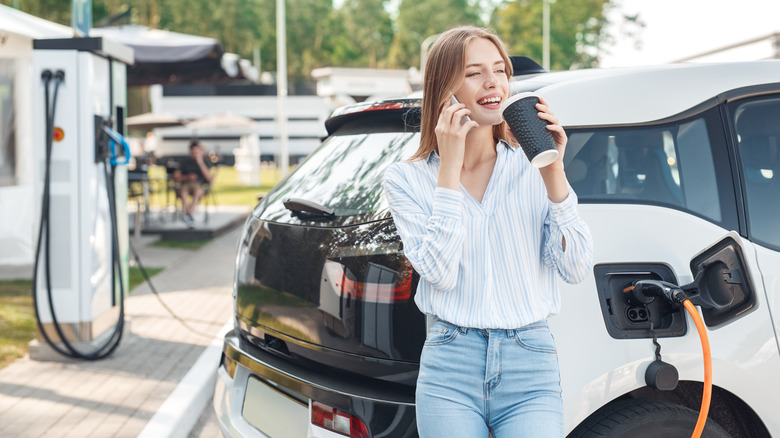 woman on phone charging car