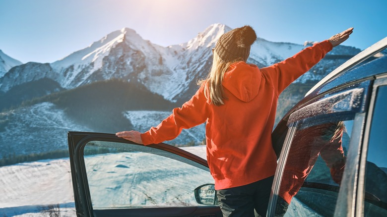 Girl stepping out of car in mountains