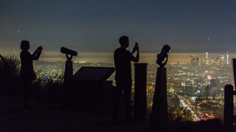 people taking photos of los angeles at night