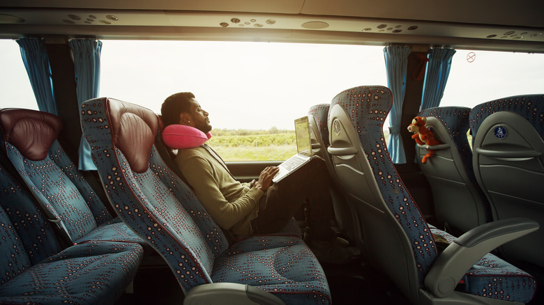 Person using laptop on bus