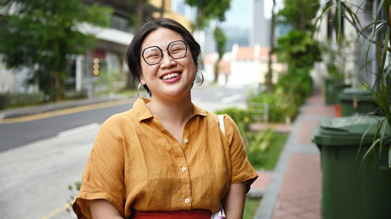 Smiling Singaporean standing outside