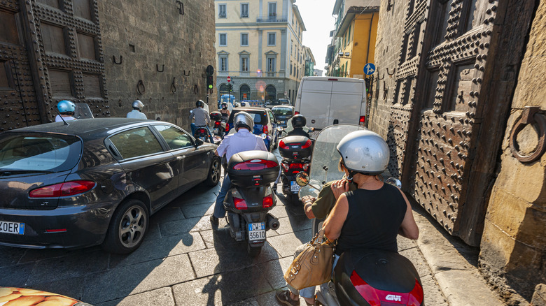 Vespa drivers wait at a busy intersection in Florence