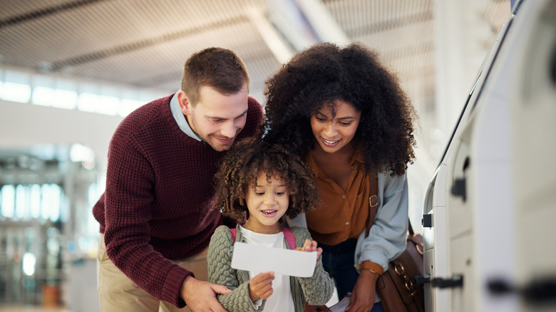 Parents with child holding ticket in an airport