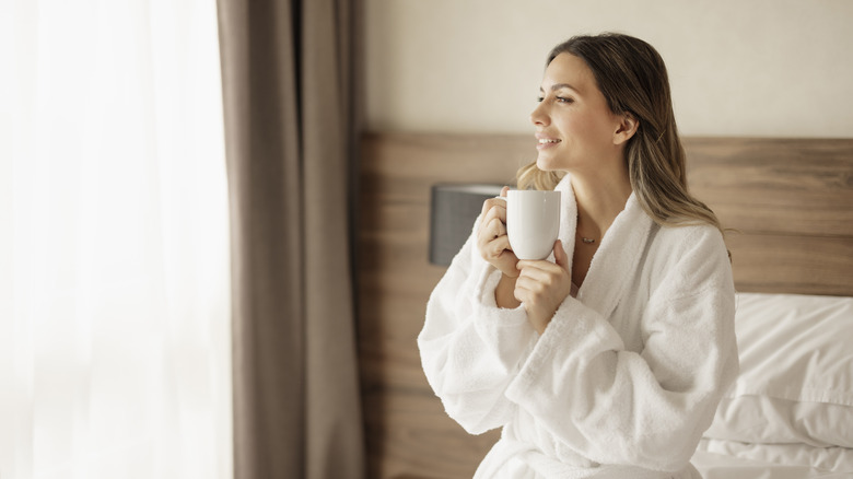 Woman in hotel bathrobe with coffee