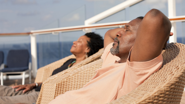 Couple sunbathing on the deck of a cruise ship