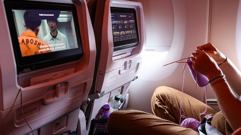 Airplane passenger knitting during flight