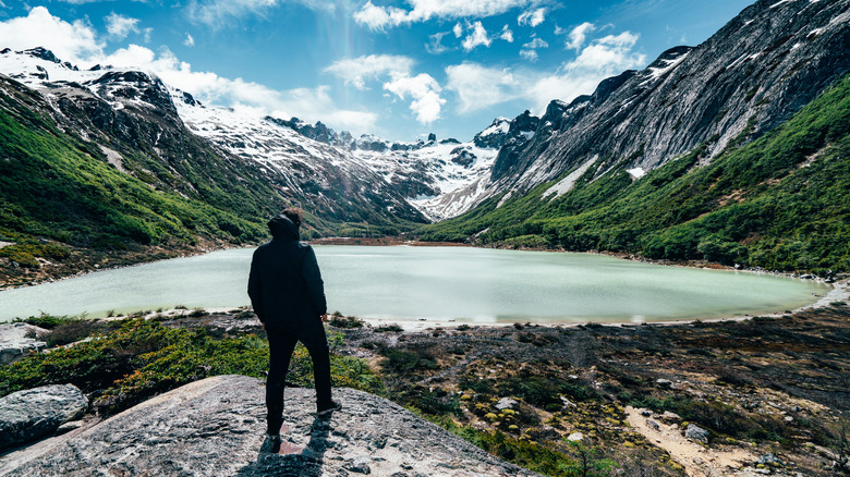 Hiker stands on the edge of a lake in Tierra del Fuego