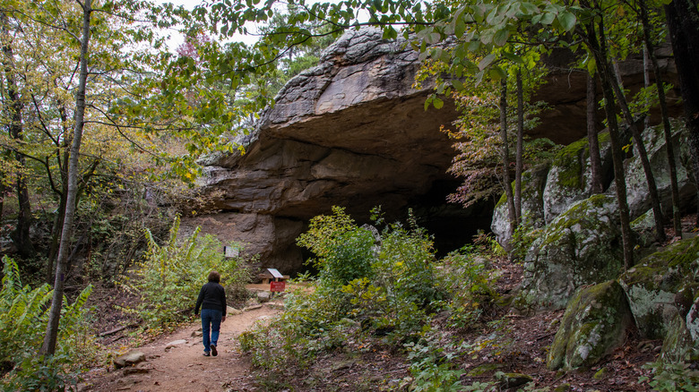 A visitor approaching Rock House Cave