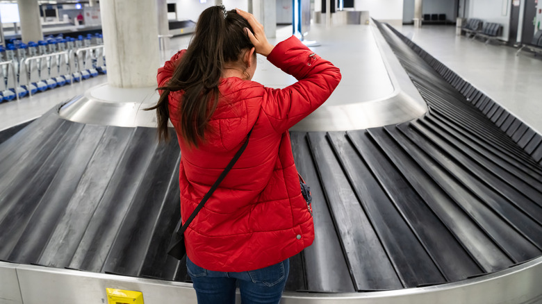 Woman at empty baggage carousel 