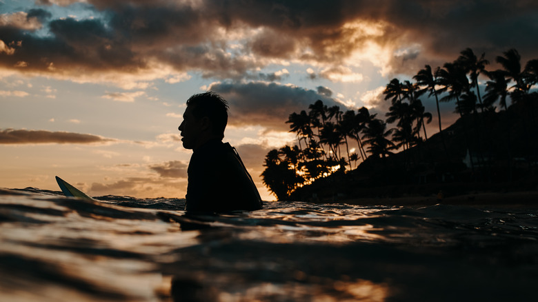 surfer at cromwell beach at sunset