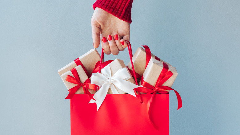 female hand holding christmas gifts