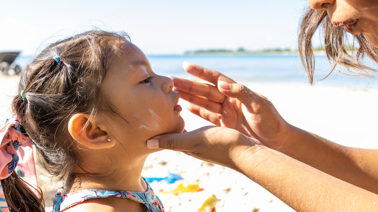 Mother applying sunscreen to child