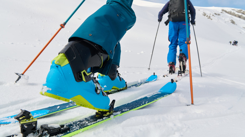 Person clicking ski boots into skis