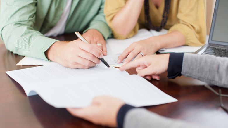 Hands signing contract