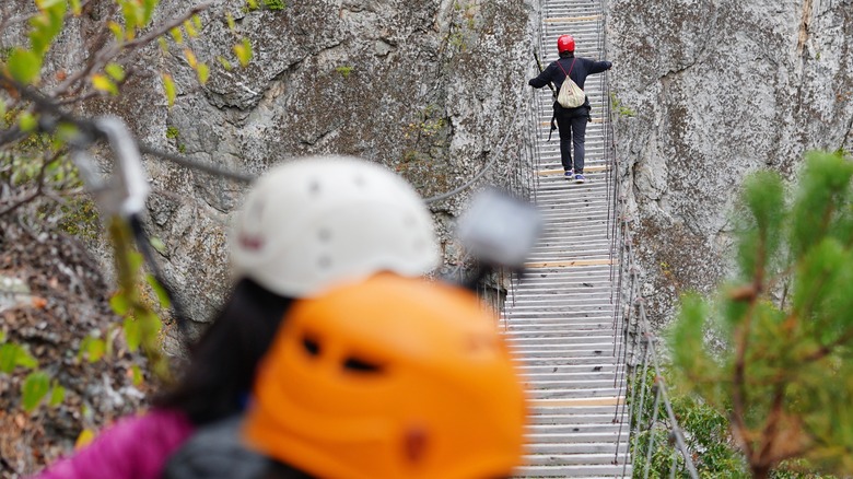 Hiker crosses swinging bridge at NROCKS