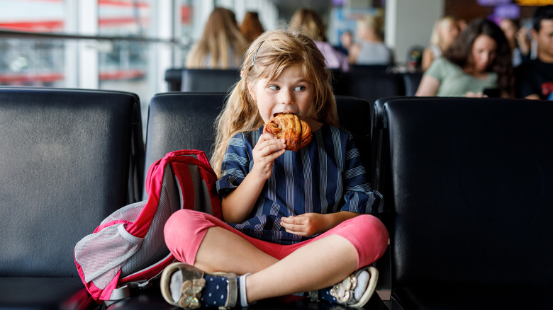 girl eating snack at airport