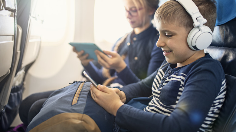 kids with electronics on plane