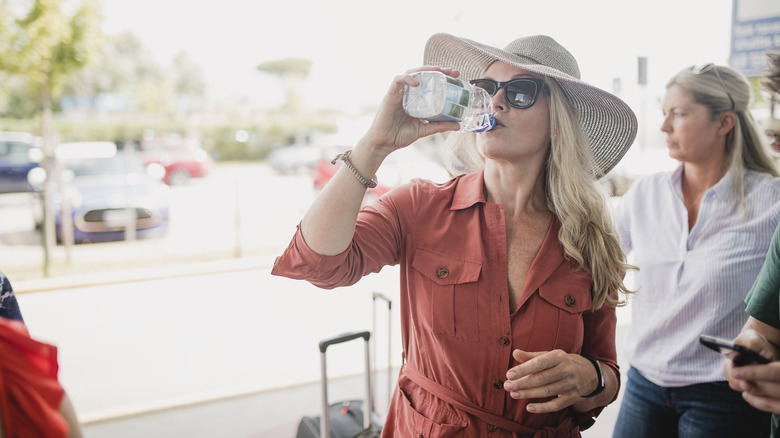 traveler drinking water at airport