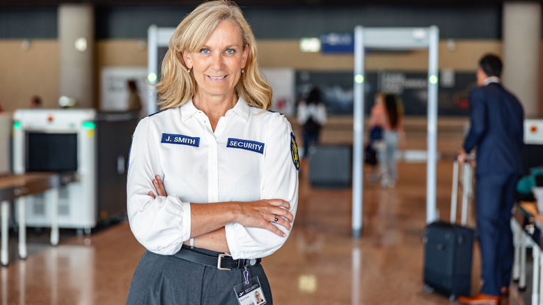 TSA agent smiling with arms crossed