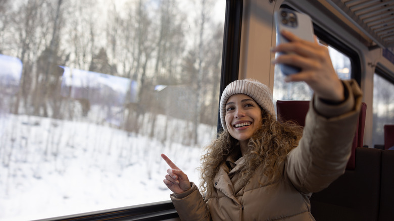 Woman taking selfie on train