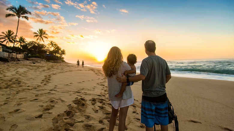 family on beach at sunset