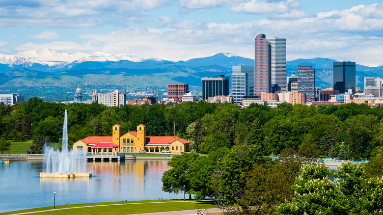 Denver skyscrapers rise in front of the Rocky Mountains on a sunny day