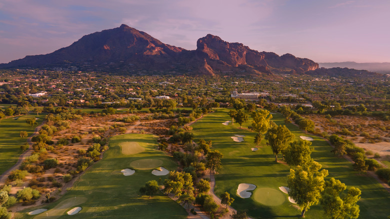 Camelback Mountain looms over Scottsdale golf courses at sunset