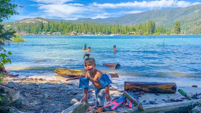 Kid wearing floaters with family in the lake